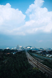 High angle view of railroad tracks by buildings against sky