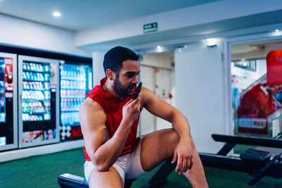 Side view of young man exercising in gym