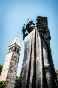 Low angle view of statue against temple against clear sky