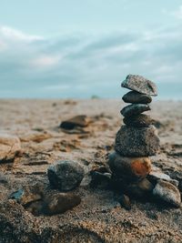 Stack of rocks at beach against sky