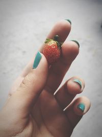 Close-up of hand holding strawberry