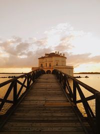 Pier over sea against sky during sunset