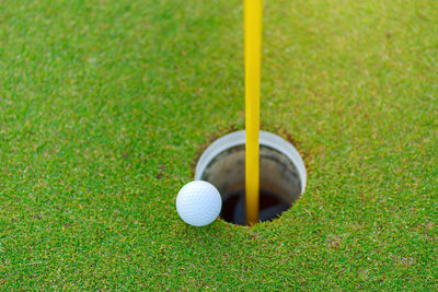 Golf ball on lip of cup at golf court