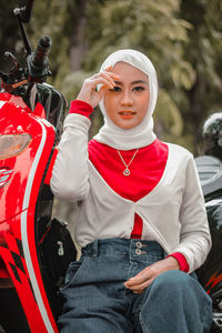 Portrait of young woman sitting on road