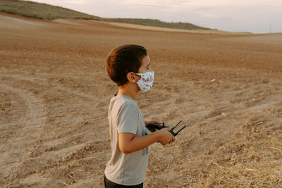 Full length of boy photographing on field