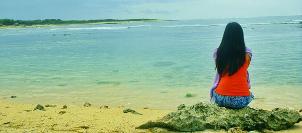 Rear view of woman looking at sea shore