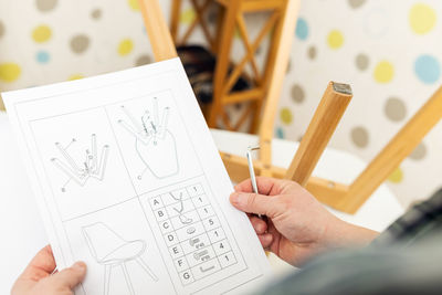 Cropped hand of woman writing in book