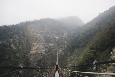 Scenic view of river by mountains against sky