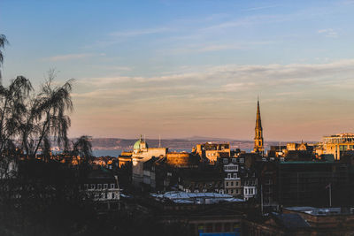 Buildings in city against sky during sunset