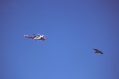 Low angle view of airplane against clear blue sky