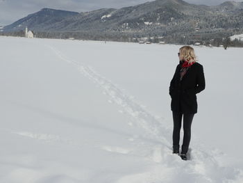 Mid adult woman standing on snow covered field