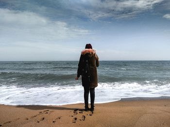 Rear view of man standing on beach