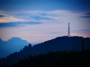 Silhouette electricity pylon against sky during sunset