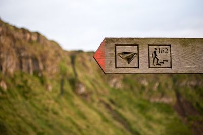 Close-up of road sign against mountain