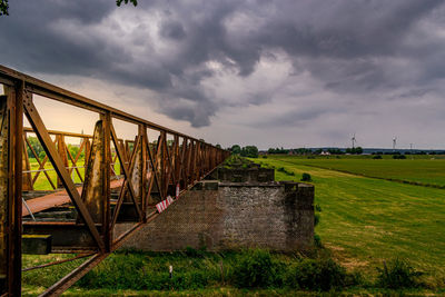 Old train bridge against cloudy sky