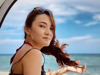 Portrait of beautiful woman against sea