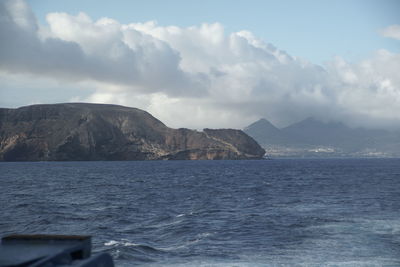 Scenic view of sea and mountains against sky