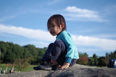 Full length of siblings relaxing on landscape