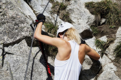 Rear view of woman standing on rock