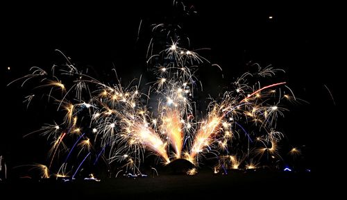 Low angle view of firework display at night