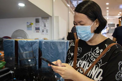 Woman wearing mask using mobile phone