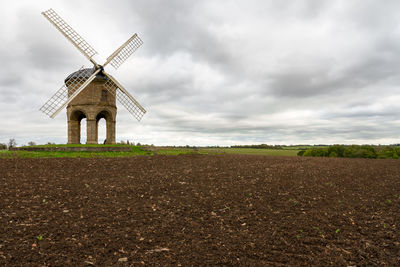 Traditional windmill on field against sky