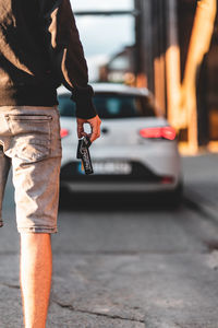 Midsection of man standing on street in city