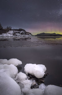 Scenic view of frozen lake against sky at night