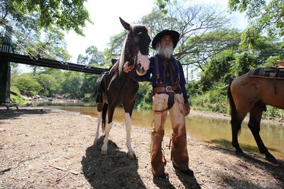 Man with horses standing by stream