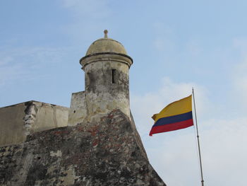 Low angle view of flag on building against sky