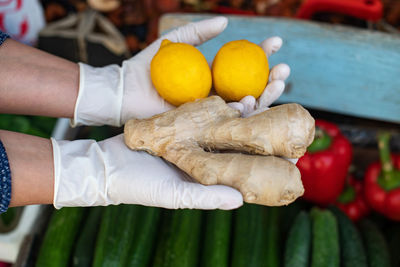 The concept of safe shopping  a woman in disposable gloves buys lemon and ginger. vitamin