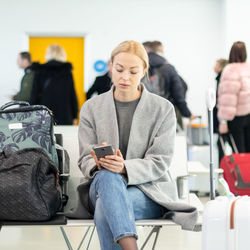 Woman using mobile phone at airport