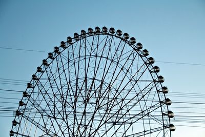 Low angle view of ferris wheel against clear blue sky