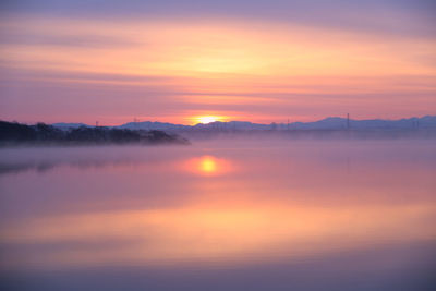 Scenic view of lake against romantic sky at sunset