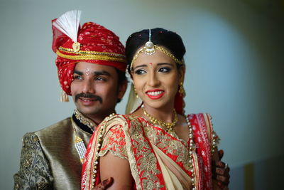 Smiling young couple standing against wall