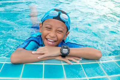 Cheerful boy laughing at poolside