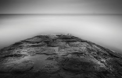 View of calm sea in front of built structure against the sky