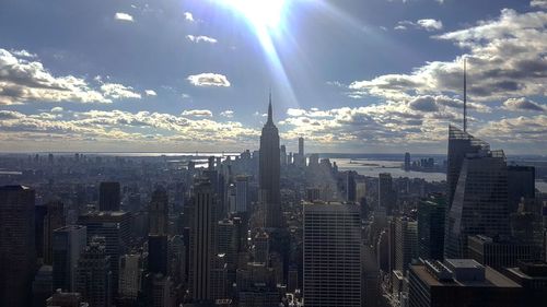 Aerial view of city against cloudy sky