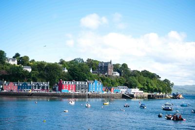 People swimming in pool by sea against sky