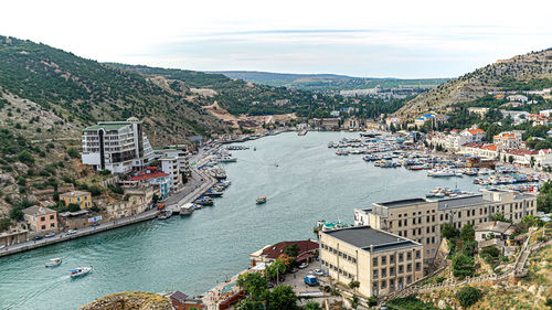 High angle view of townscape by sea against sky