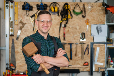 Portrait of young man standing in workshop