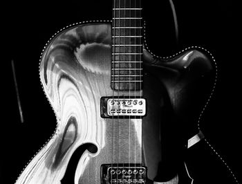 Close-up of guitar against black background