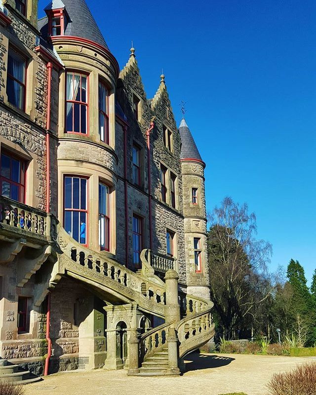 architecture, built structure, building exterior, clear sky, blue, sunlight, day, tree, house, residential structure, residential building, shadow, incidental people, outdoors, building, facade, city, sky, travel destinations, no people