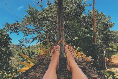 Low section of person relaxing on hammock