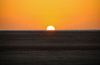 Scenic view of sea against orange sky