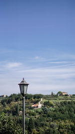 Street light by building against sky