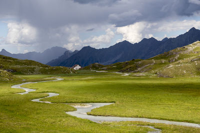 Scenic view of field and mountains against sky