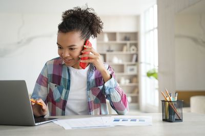 Portrait of young woman using laptop at home