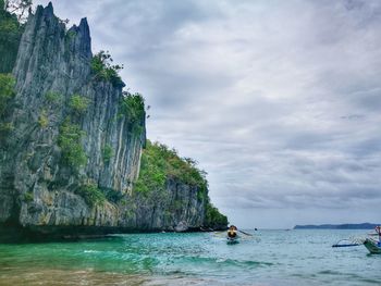 Scenic view of cliff by sea against sky