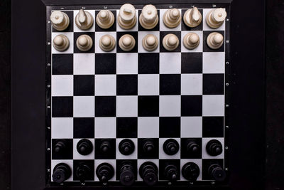 Chess on board with dark background.